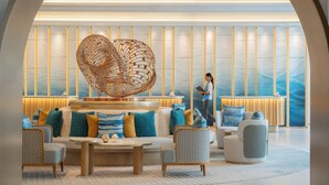 A modern lobby with a central seating area, a large abstract sculpture, and a person standing by the wall. - Melia Pattaya Hotel (Pattaya)