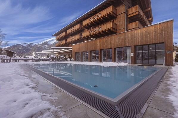 A modern building with a pool, wooden balconies, and a snowy landscape. - Attractive chalet in Ehrwald (No Deposit) (Ehrwald)