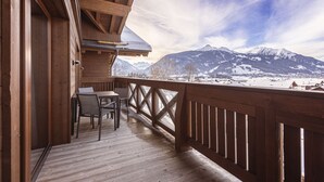 A wooden deck with a table and chairs, overlooking a snowy mountain landscape. - Welcoming chalet with balcony (No Deposit) (Ehrwald)