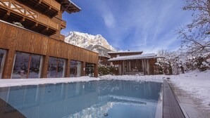 A wooden building with a pool, snow-covered surroundings, and a mountain in the background. - Welcoming chalet with balcony (No Deposit) (Ehrwald)