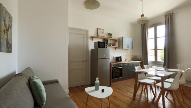 Un espacio habitable compacto con kitchenette, comedor y sofá.