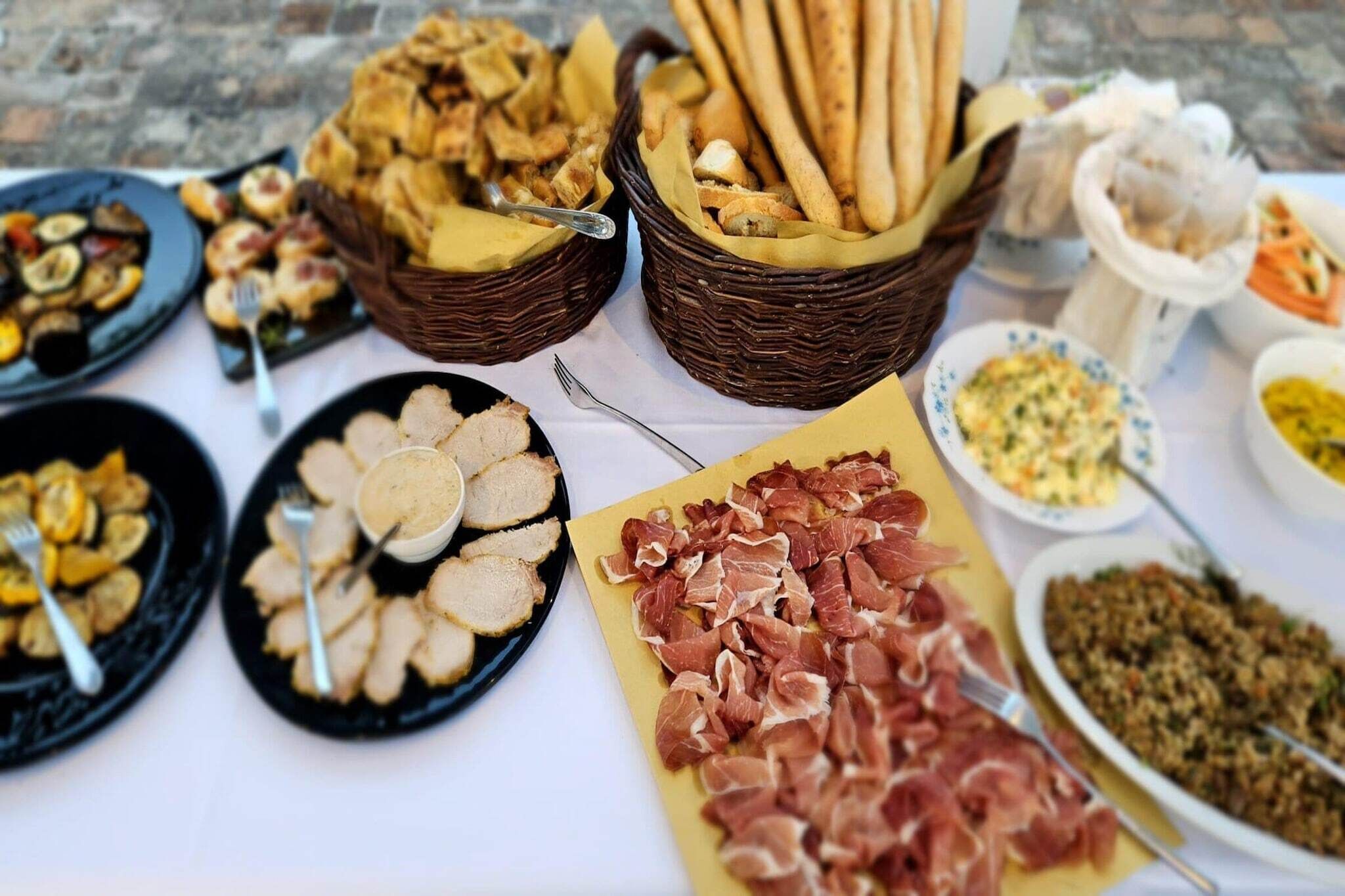 A table with various food items including bread, meats, and vegetables.