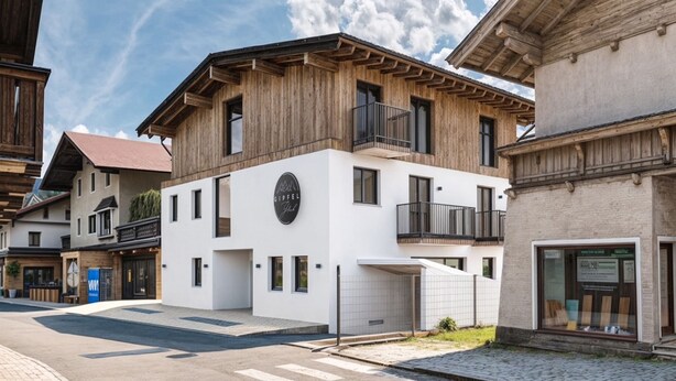 A modern building with a wooden facade, a balcony, and a sign that reads "GIRFEL." - Apartment in Kirchberg near Schaterzlift (Kirchberg in Tirol)