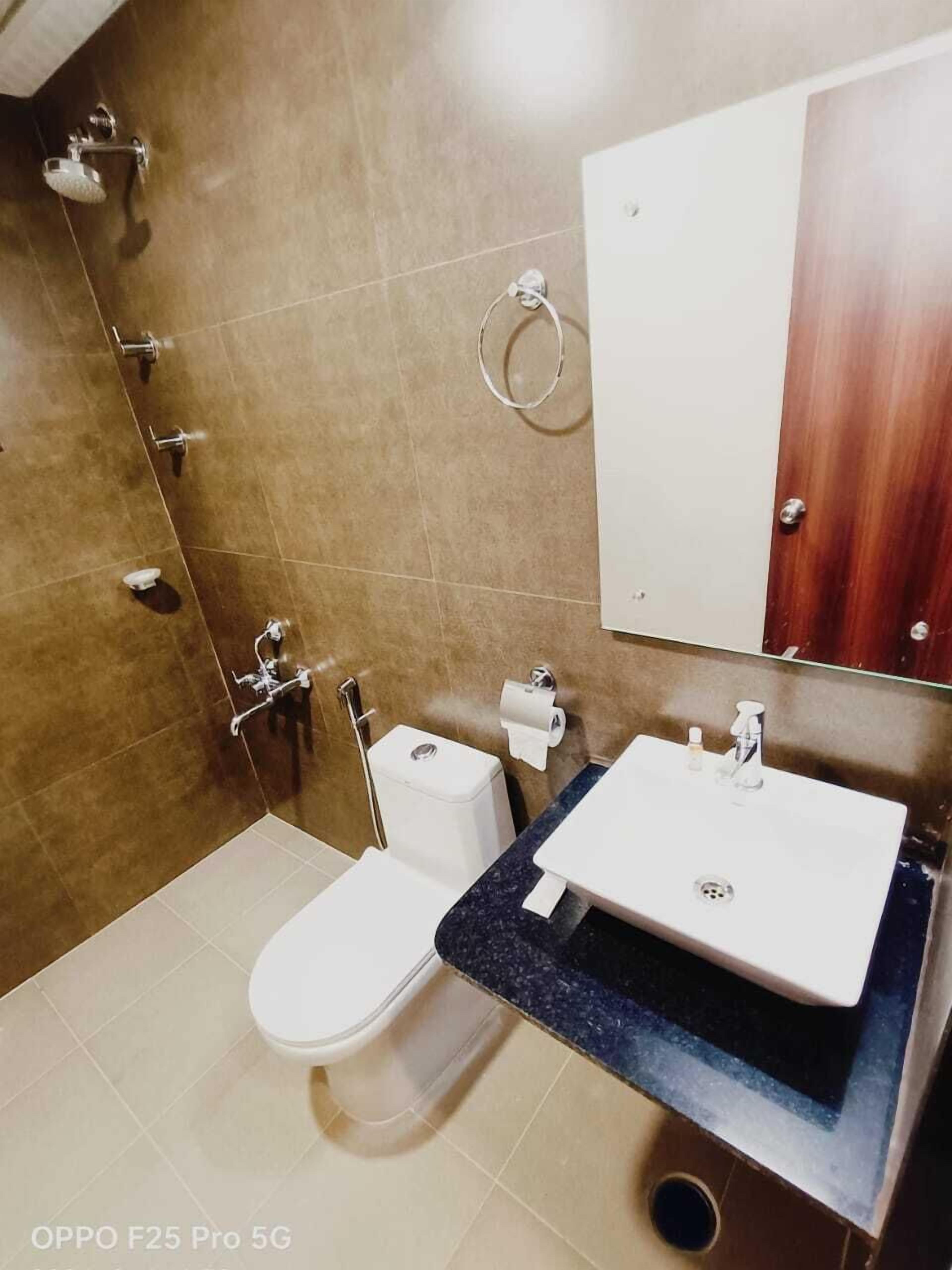 A bathroom with a toilet, bidet, sink, and mirror.