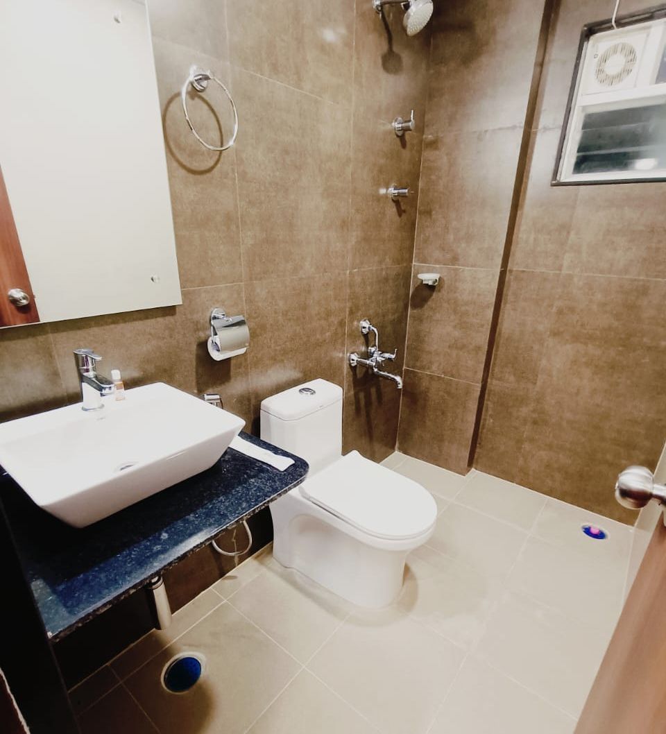 Un baño con lavamanos, inodoro y ducha blancos.