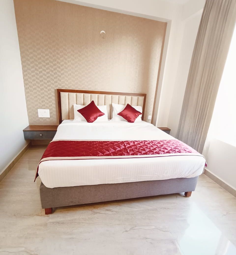 A hotel room with a large bed, a headboard, and a nightstand.