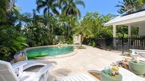 A backyard with a swimming pool, surrounded by lush greenery and palm trees. - Sorrento Breeze | Port Douglas (PORT DOUGLAS)