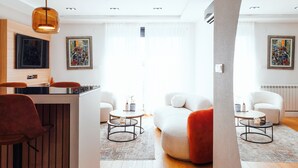A modern living room with a wooden bar, white sofas, and a red chair. - Belgrade Rooftop Experience, Modern Luxury & Views (Beograd)