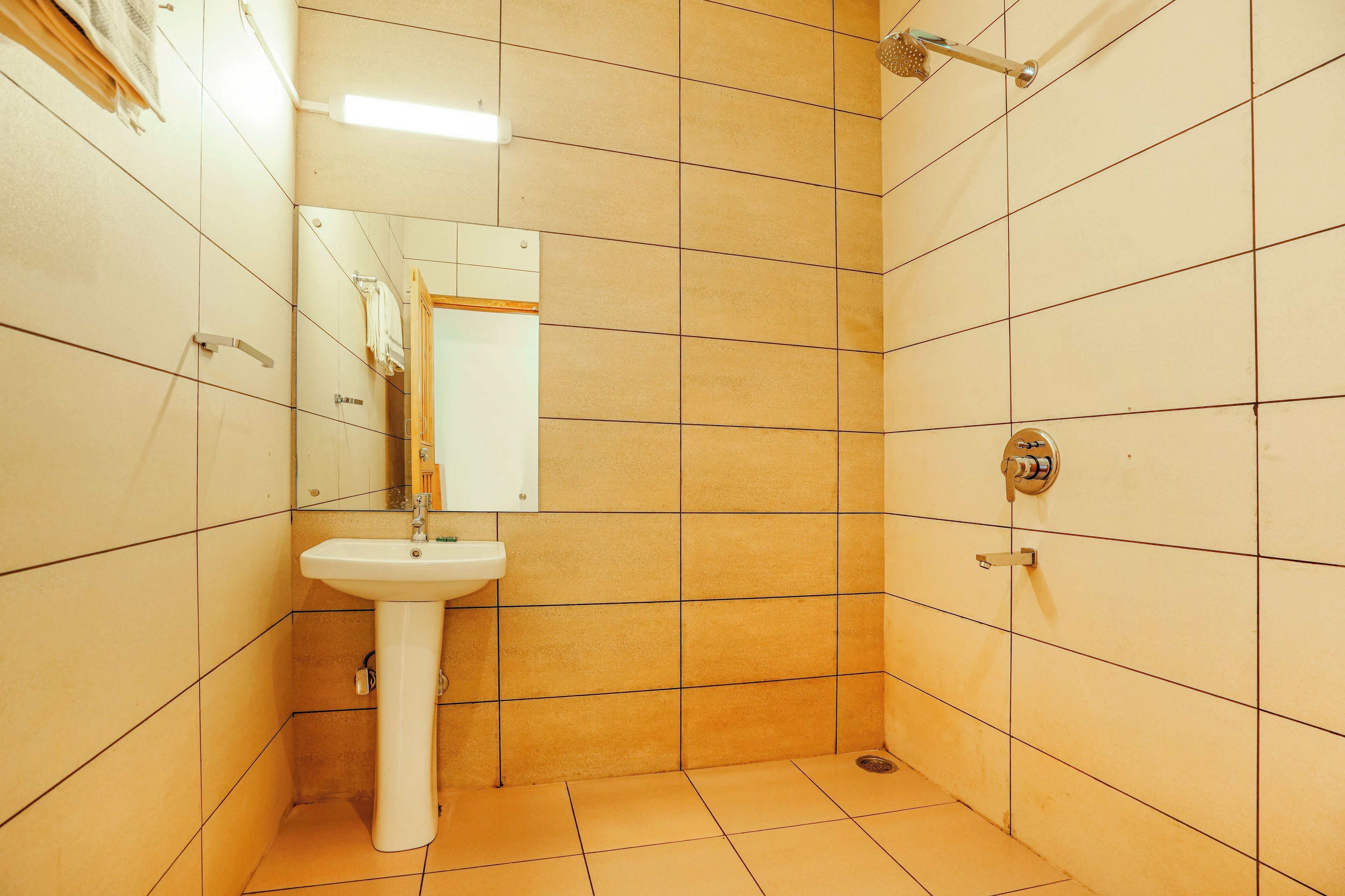 A bathroom with a sink, mirror, and shower.