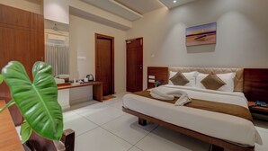 Ein modernes Hotelzimmer mit einem großen Bett, einem Schreibtisch und Blick aufs Meer.