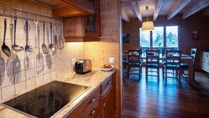 A wooden interior with a kitchen featuring a stove, a toaster, and utensils hanging on the wall. - Wonderful private villa for 8 guests with terrace (Alpe Des Chaux)