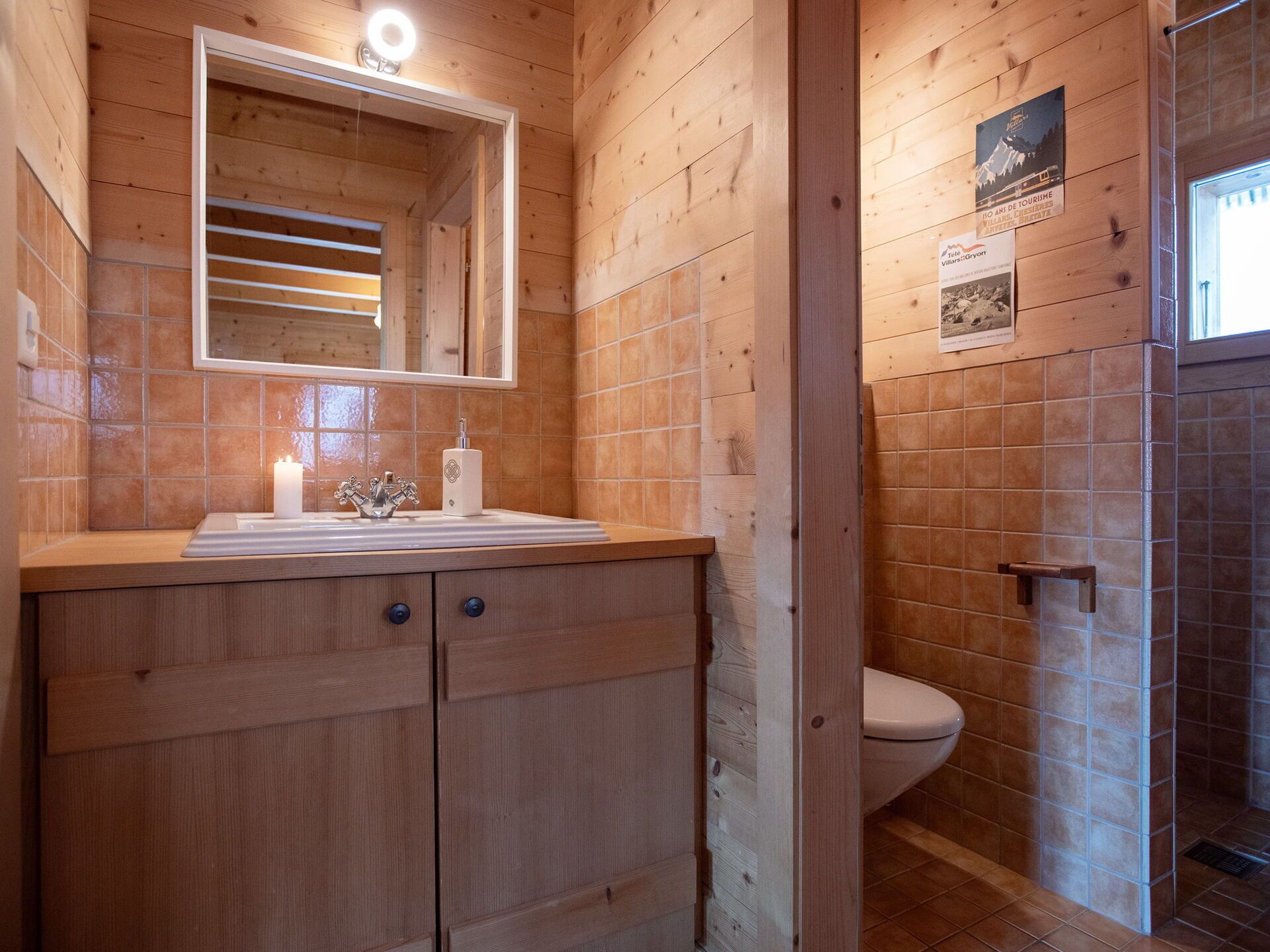 Ein Badezimmer einer Holzhütte mit Waschbecken, Spiegel und Toilette.
