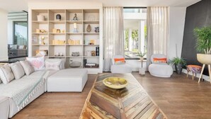 Uma sala de estar moderna com um sofá seccional, uma mesa de centro de madeira e uma estante embutida.