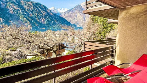 A balcony with a wooden railing overlooking a mountainous landscape with snow-capped peaks. - Lovely apartment for 4 people with A/C, WIFI, TV and terrace (Giustino)