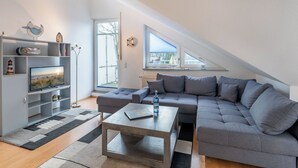 A modern living room with a grey sectional sofa, a coffee table, and a TV on a grey entertainment unit. - House Dünenwald 11 - small, cozy domicile with balcony (Zinnowitz)