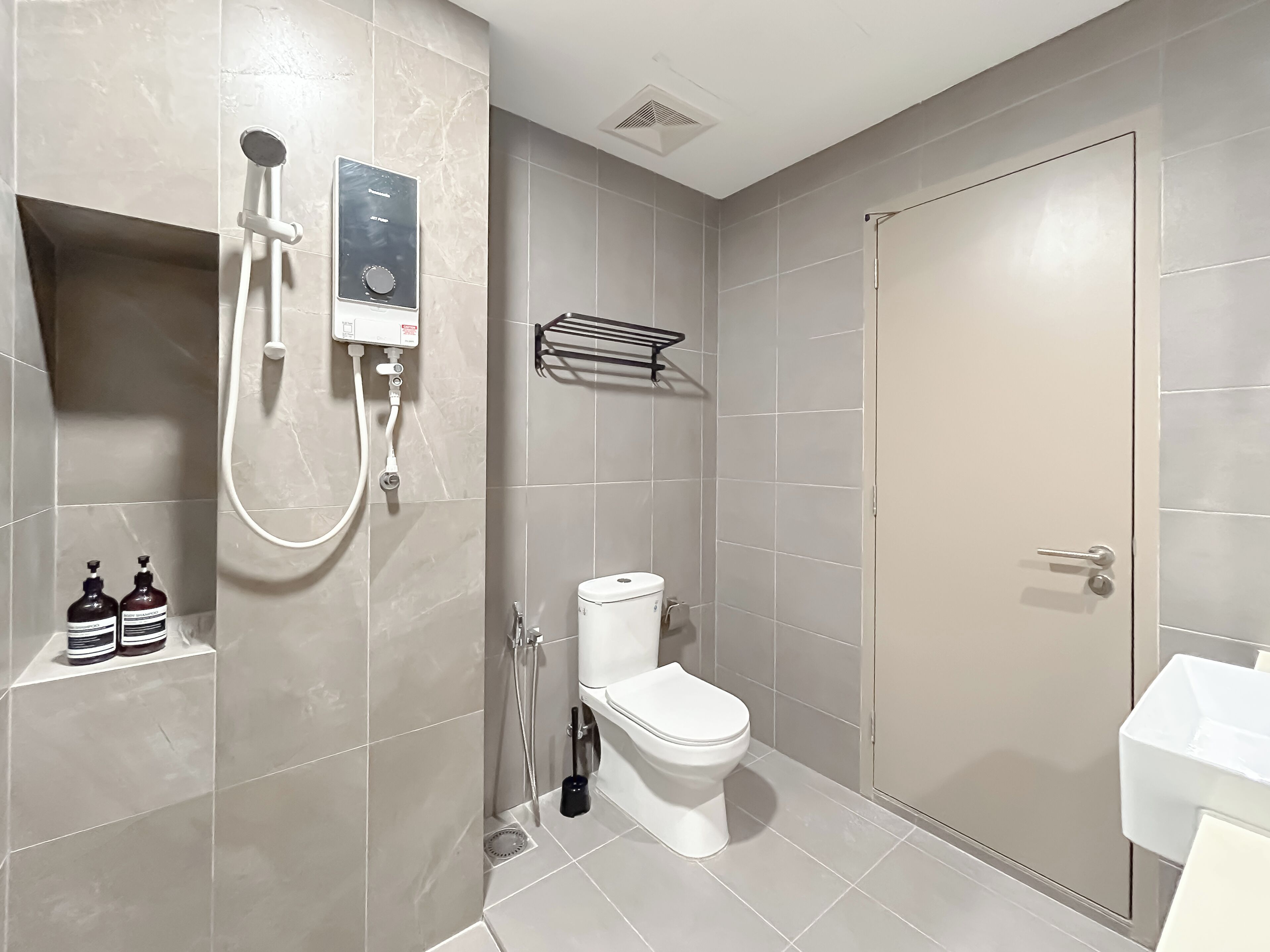 Une salle de bain moderne équipée d’une douche, de toilettes et d’un lavabo.