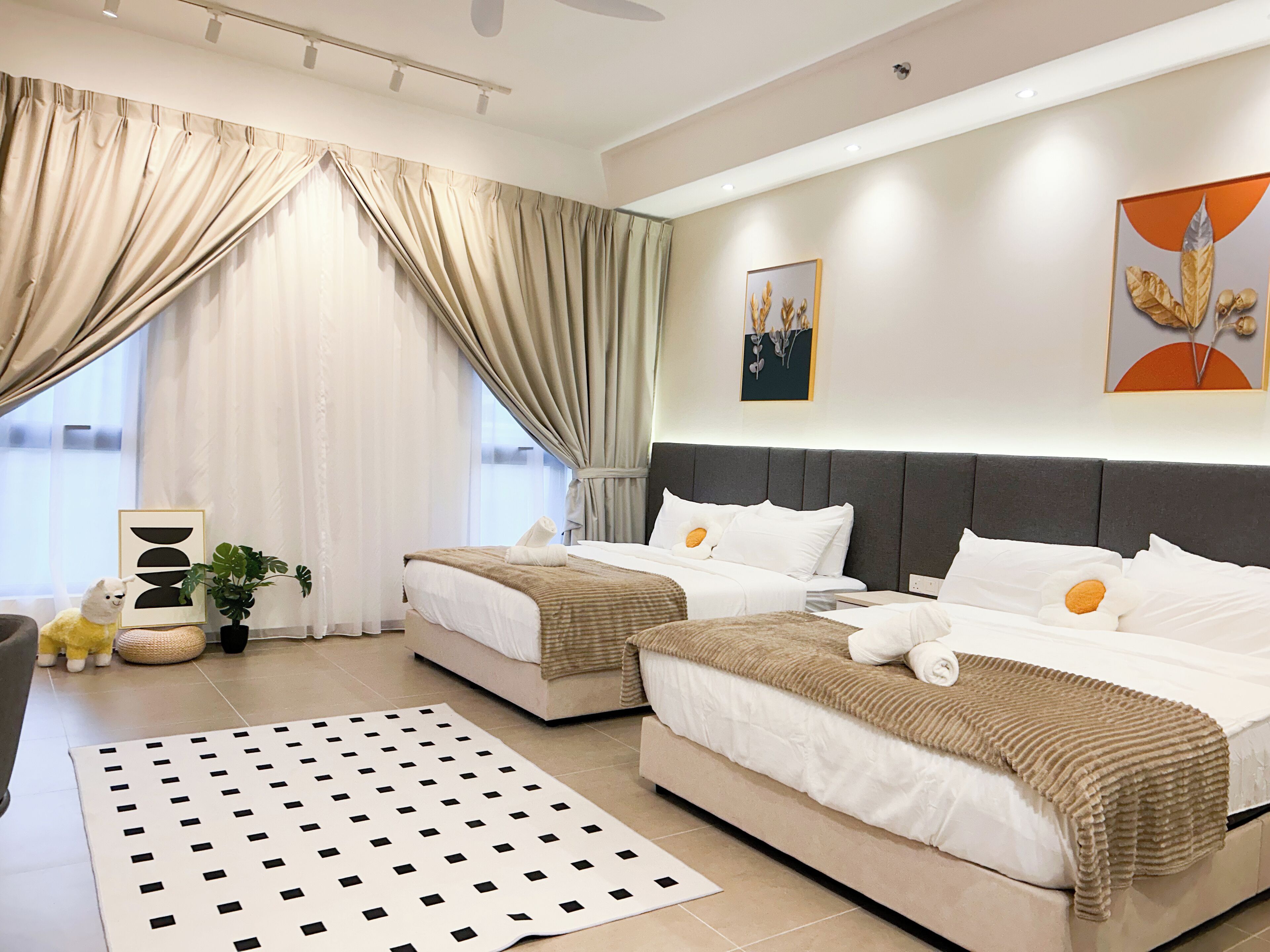 A modern hotel room with two beds, a large window with curtains, a flat-screen TV, and a decorative plant.