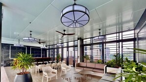 A modern lounge area with seating, tables, and ceiling fans. - Mossaz by Manhattan Group  (Petaling Jaya)