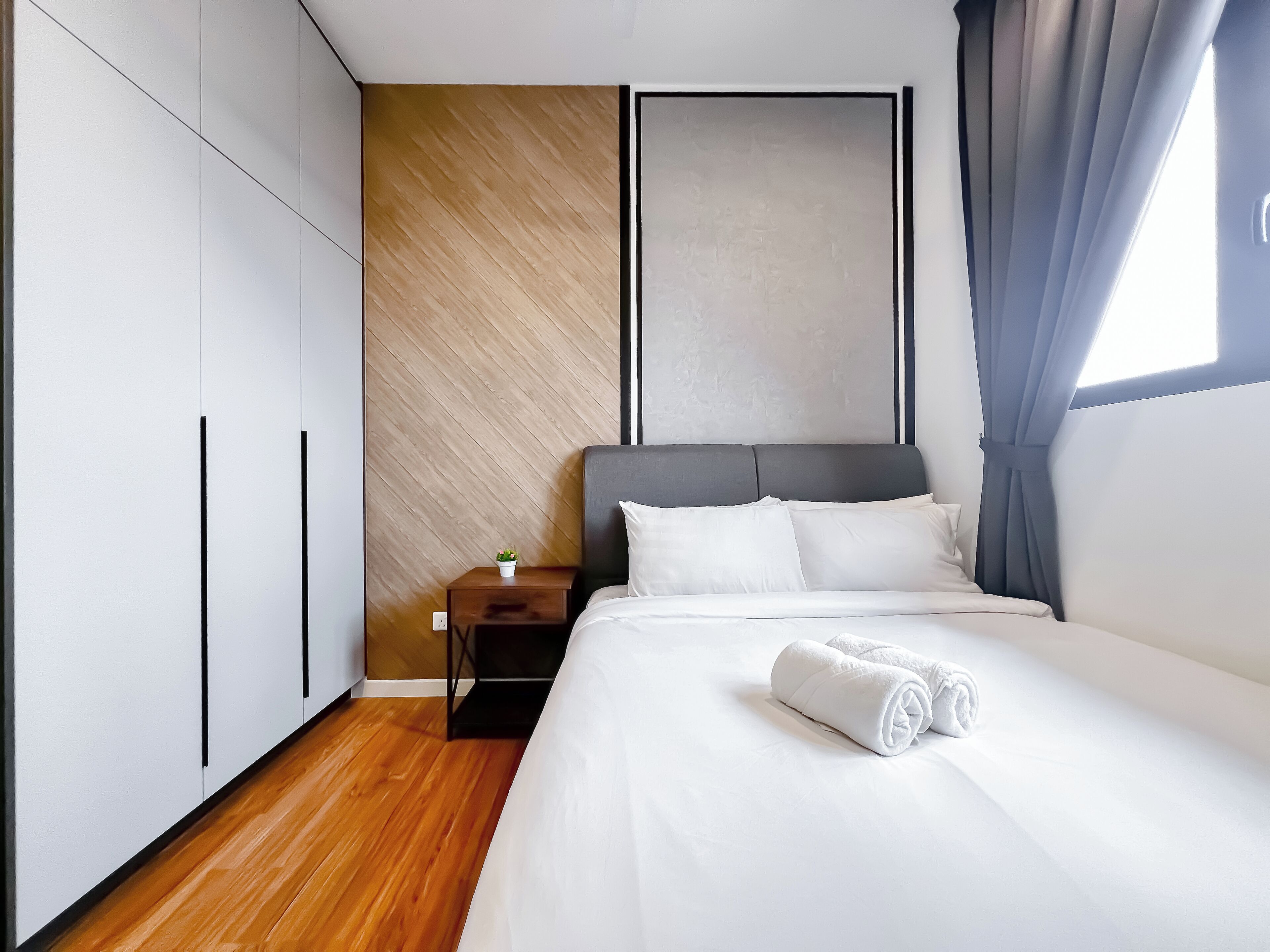 Ein modernes Schlafzimmer mit Bett, Nachttisch und Kleiderschrank.