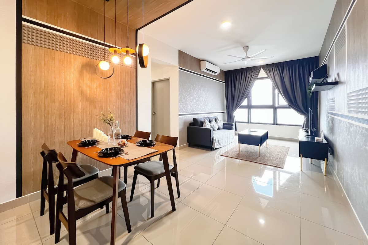 Un salon moderne comprenant un coin repas, un canapé, un ventilateur de plafond et une grande fenêtre avec des rideaux.