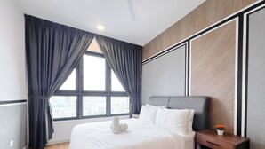 Et moderne hotelværelse med en stor seng, et natbord og udsigt over byen gennem et stort vindue med gardiner.
