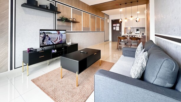 En moderne stue med et fladskærms-tv, en sort multimediemøbel, en grå sofa og en loftsvifte.