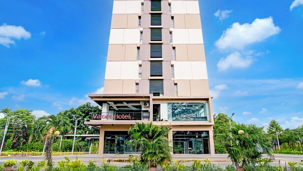 A tall hotel with a modern design, featuring a prominent entrance and a sign that reads "Varen Hotel." - Collection O Apartment By Boboin Baros Near Stasiun Cimahi (Cimahi)