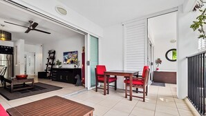 Un salon moderne avec un canapé, une table en bois et un coin repas avec des chaises rouges.