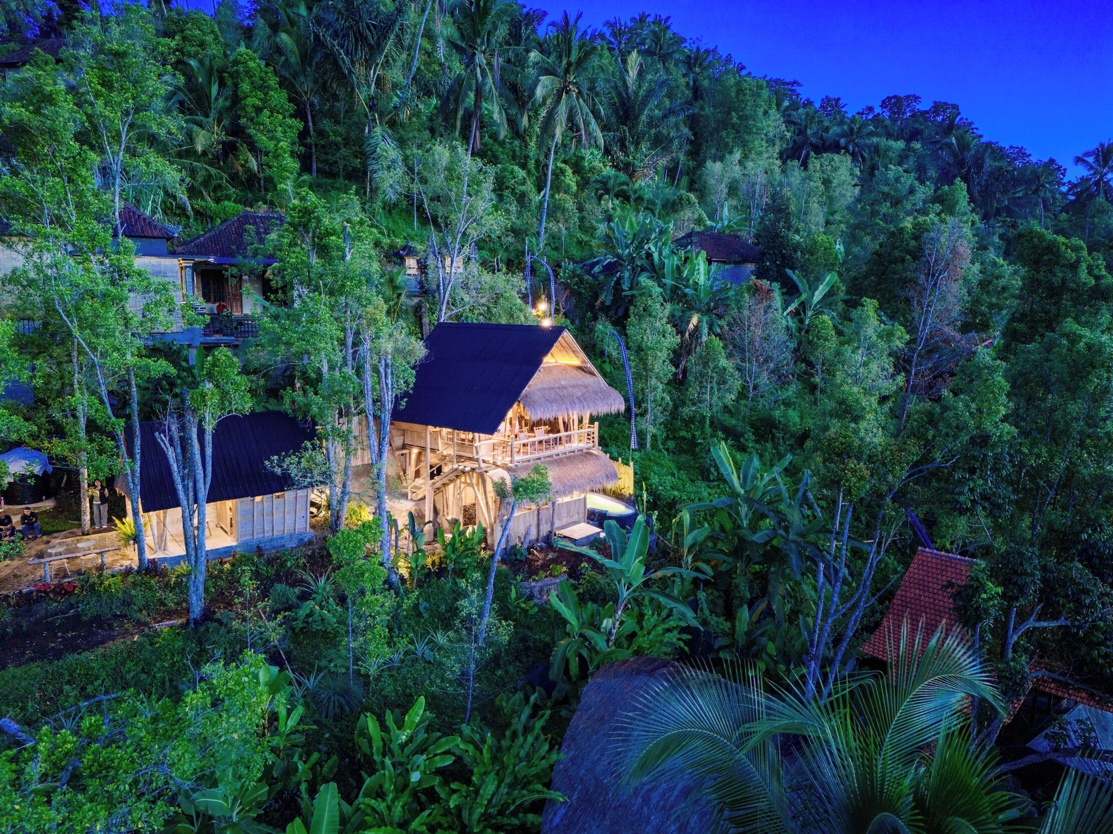 Un resort con varias edificaciones de madera rodeado de exuberante vegetación tropical.
