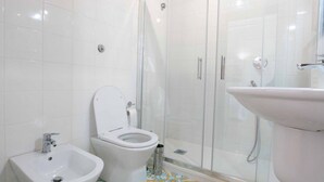 Une salle de bain équipée de toilettes, d’un bidet et d’une douche.