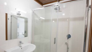 A modern bathroom with a glass-enclosed shower, a white sink, and a mirror. - Arcoleo Prestige 2 By Dimorra (NAPOLI)