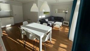 A modern living space with a dining area, sofa, and kitchen. - Exclusive Apartment With Scenic View (Bad Kleinkirchheim)