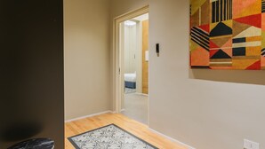 A hallway with a patterned rug, a door leading to a bedroom, and a colorful wall hanging. - Cognetti Suite 2 in Bari (Bari)
