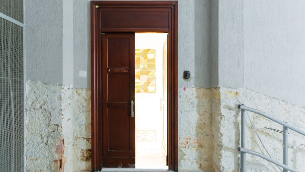 A hallway with a wooden door leading to a bright room. - Cognetti Suite 2 in Bari (Bari)