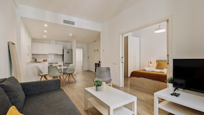 Un appartement moderne comprenant un salon, un coin repas, une cuisine et une chambre.