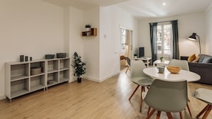 Un salon moderne avec un coin repas, comprenant un canapé, une table basse et un téléviseur.