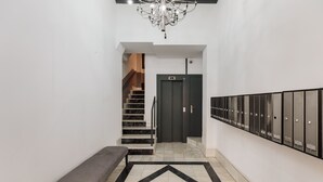 Ein Flur mit einer Bank, einer Treppe, einer Tür und einer Reihe von Schließfächern.
