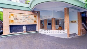 Legian Beach Walk -hotellin ulkoasu Balilla: hotellissa on kaareva sisäänkäynti, vastaanottoalue, jossa on palvelutiski, ja sen edessä seisoo patsas.