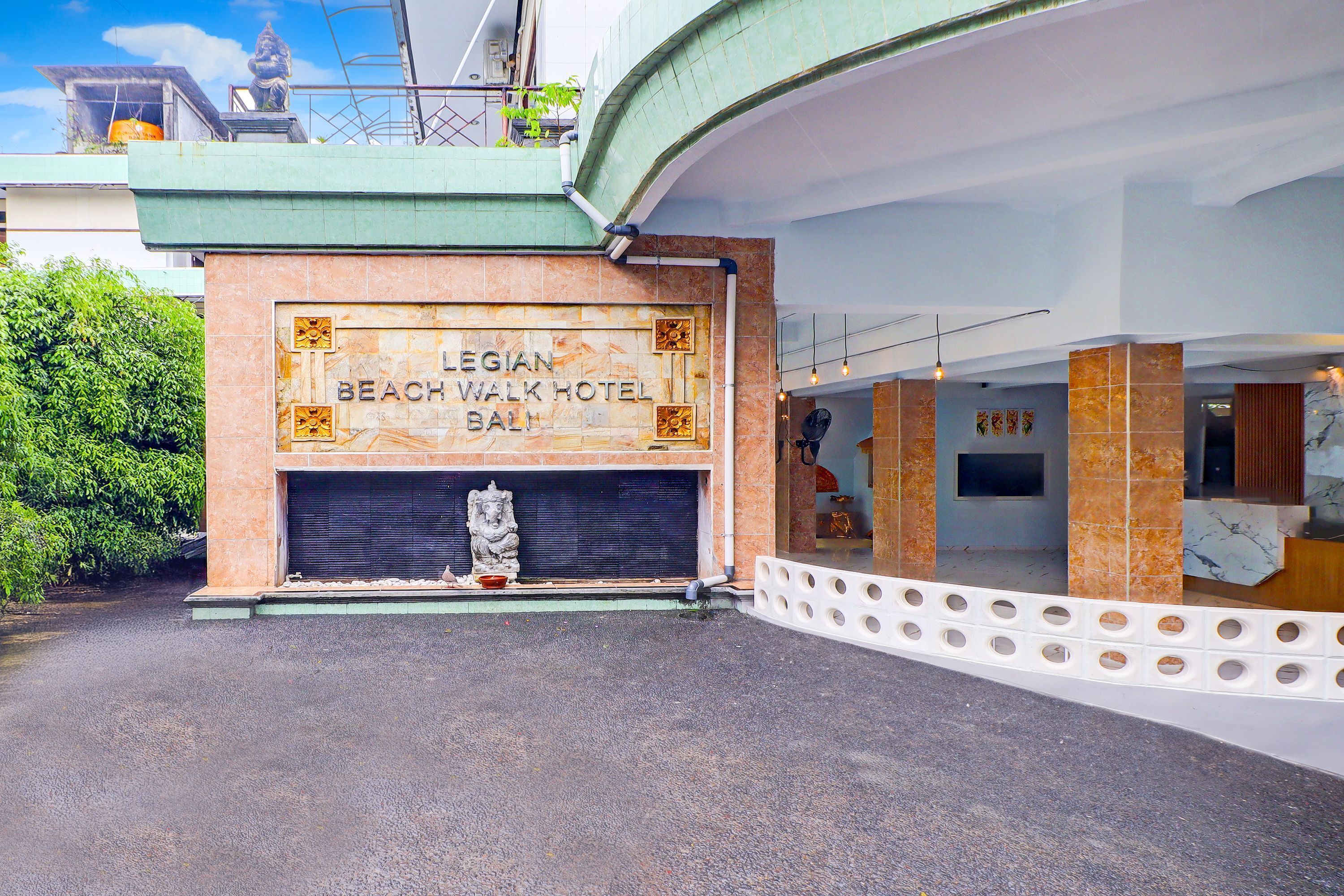 The exterior of the Legian Beach Walk Hotel in Bali, featuring a prominent entrance with a decorative facade and a statue.