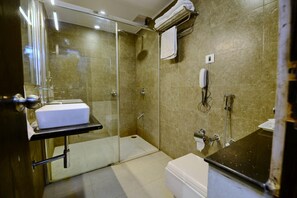 A modern bathroom with a glass-enclosed shower, a white sink, and a toilet. - HOTEL FLORET INN (Durg)