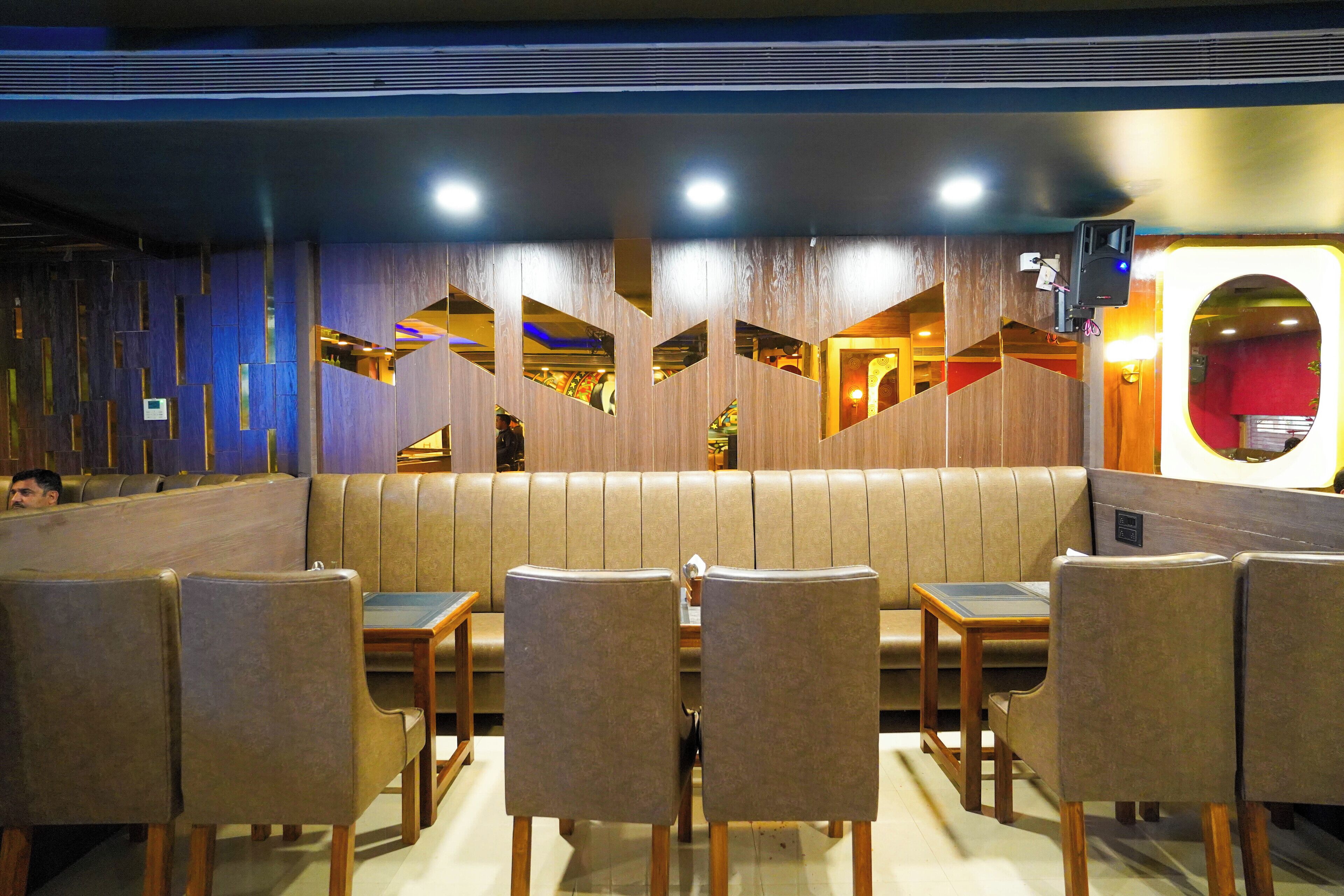 Un restaurante con asientos tipo cabina y mesas de madera.