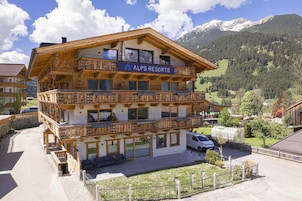 A wooden multi-story building with balconies, labeled "ALPS RESORTS."