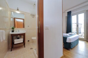 Une chambre d’hôtel avec salle de bain, un lit et un balcon.
