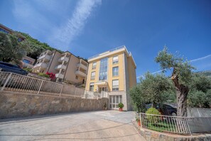 Situated on a charming street, this building features a balcony and potted plants.