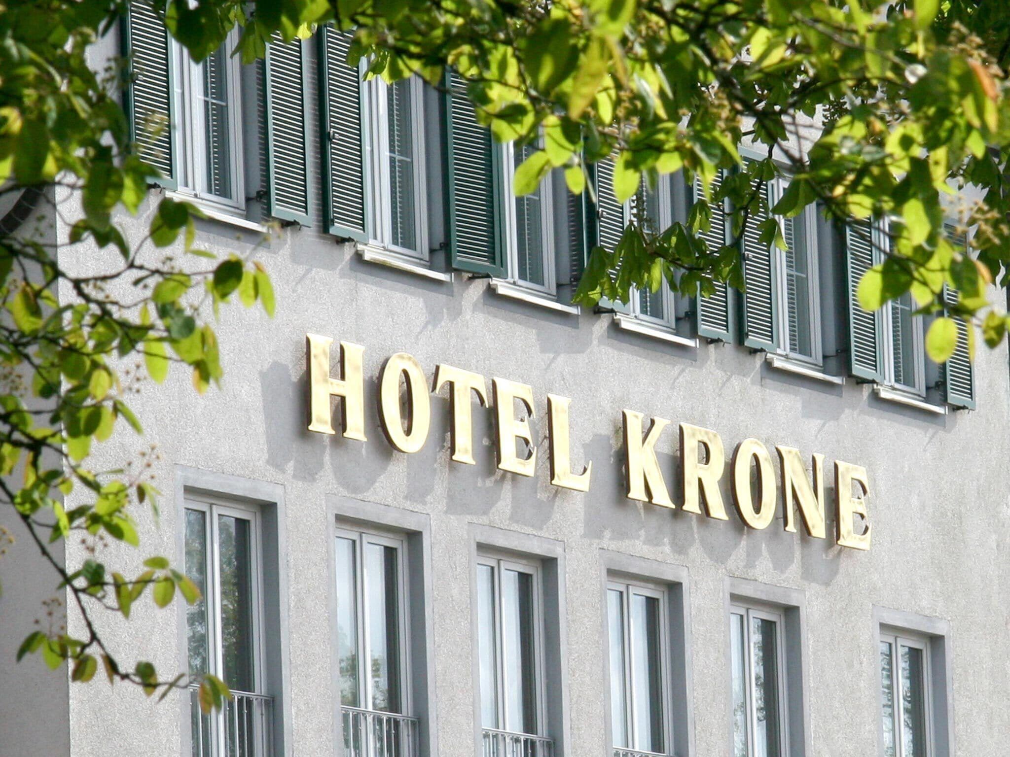 Een gebouw met het bord 'HOTEL KRONE', wat een hotel aangeeft.