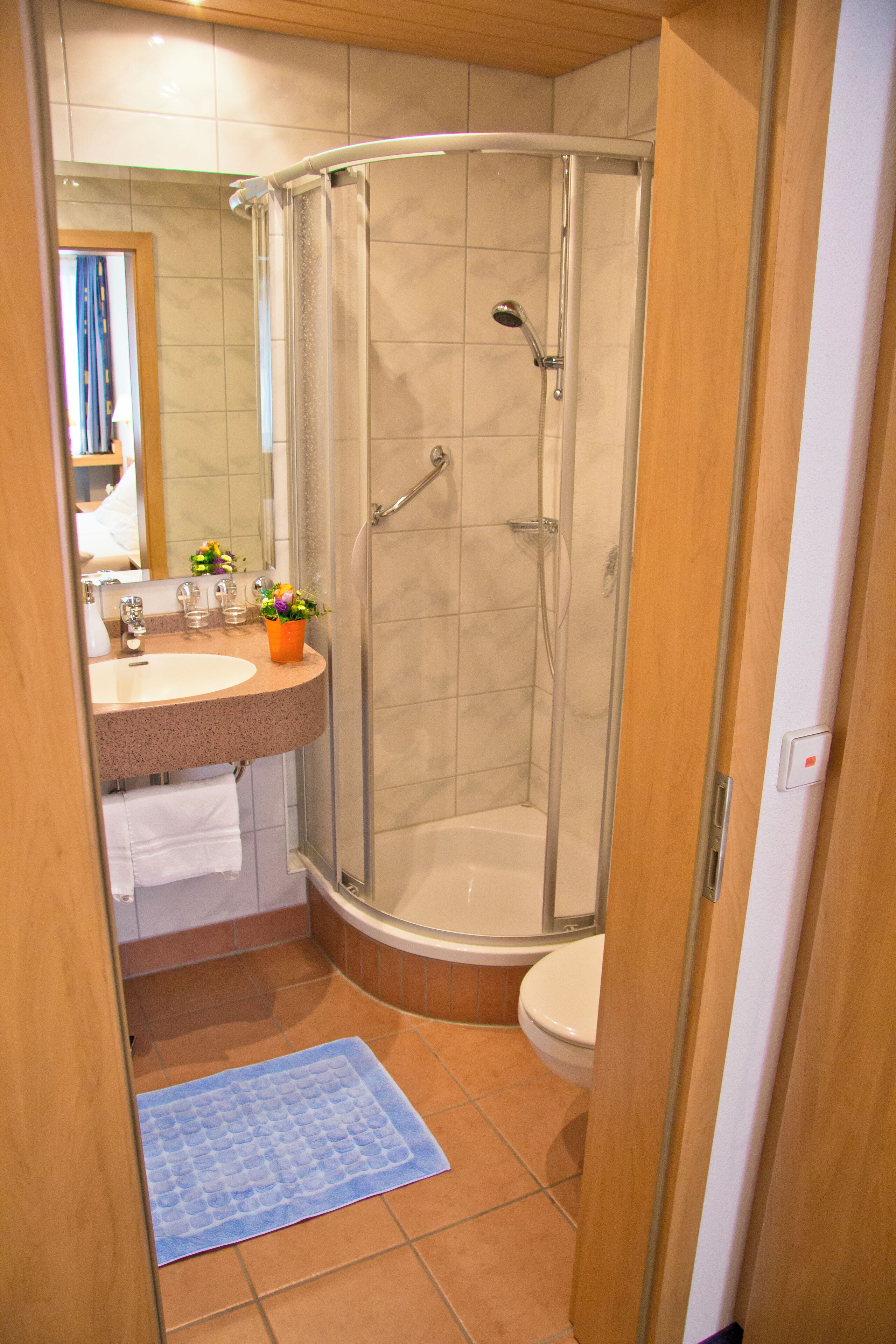 Ein Badezimmer mit Dusche, Waschbecken und Toilette.