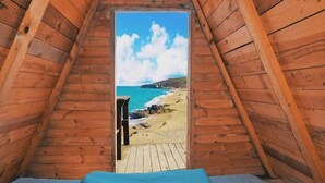 A wooden cabin with a view of a beach through a window. - Sahil Kamp Istanbul Hotel (Sile)