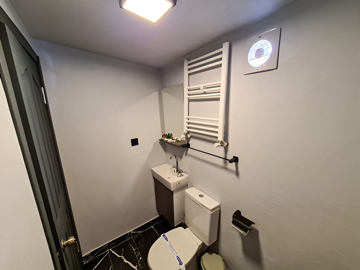 Ein kleines Badezimmer mit Toilette, Waschbecken und Handtuchhalter.