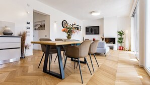 A modern dining area with a wooden herringbone floor, a central table, and contemporary chairs. - Villa with heated pool 2 steps from the sea (Quartu Sant'Elena)