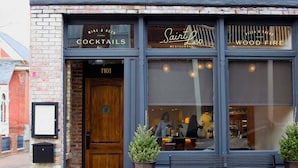Un restaurante con fachada de ladrillo, una puerta de madera con la inscripción "1101" y un letrero que dice "Saint Leo Restaurant".
